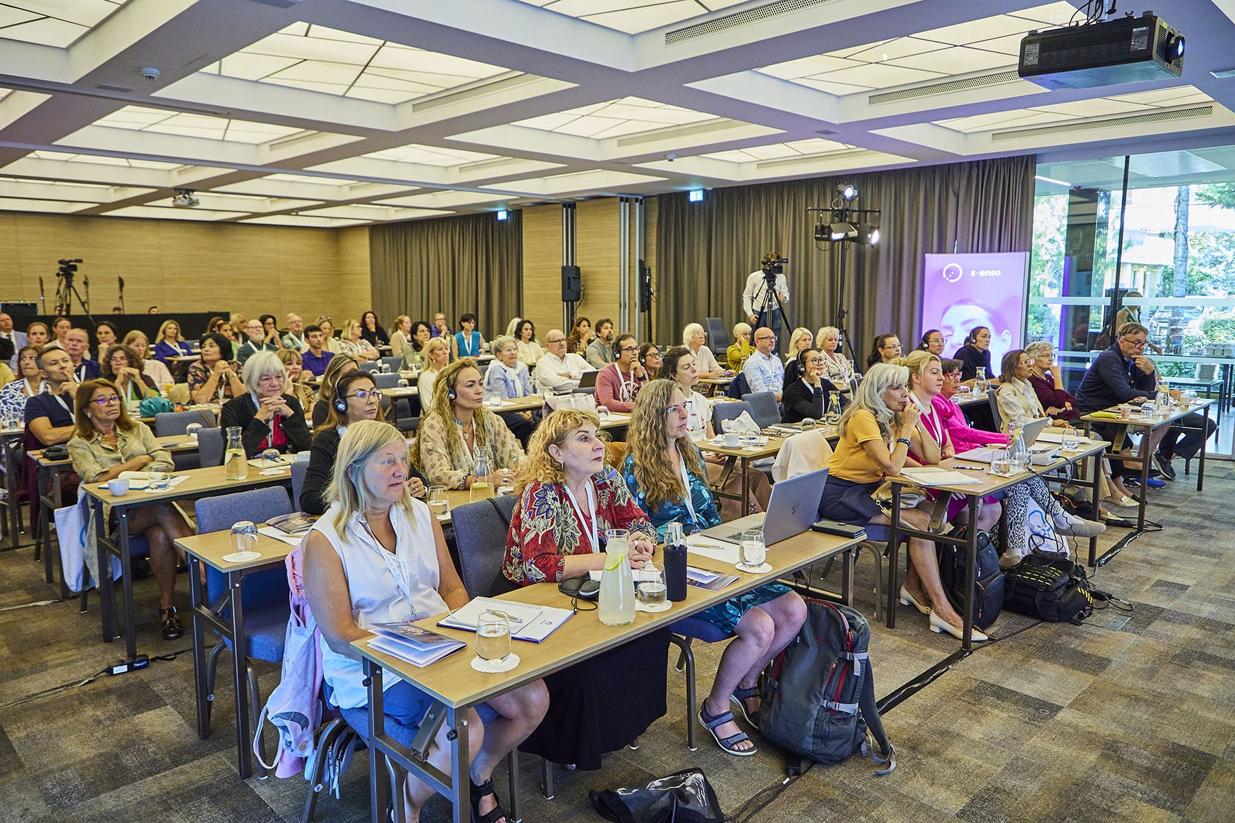 Conference attendees focused on speaker presentation indoors