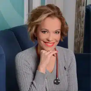 Smiling woman with short hair wearing a grey sweater