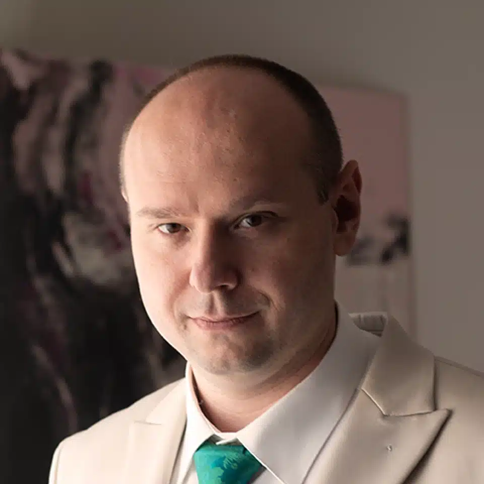 Hombre calvo con traje blanco y corbata verde